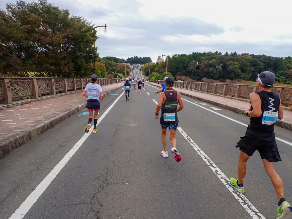 装飾のある欄干が続く橋の上を走るランナーたち