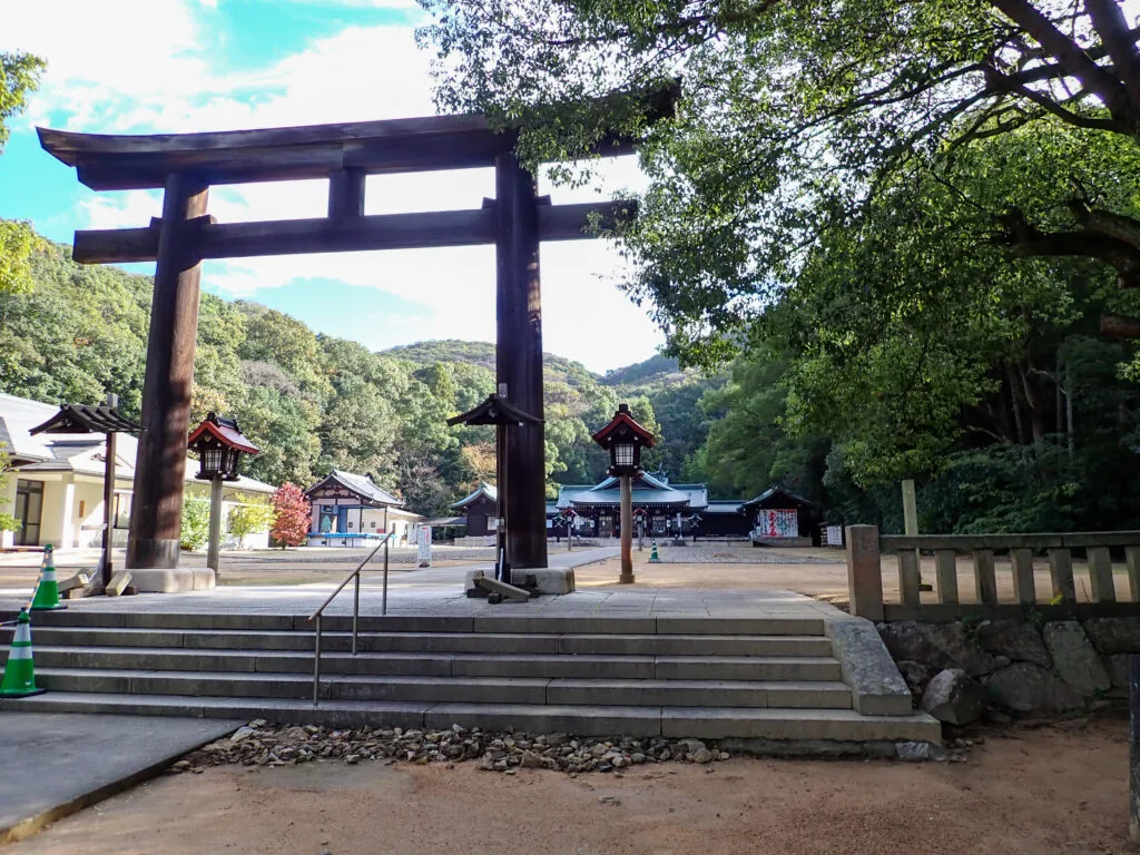 木造の大鳥居と、その奥に見える岡山縣護国神社の社殿