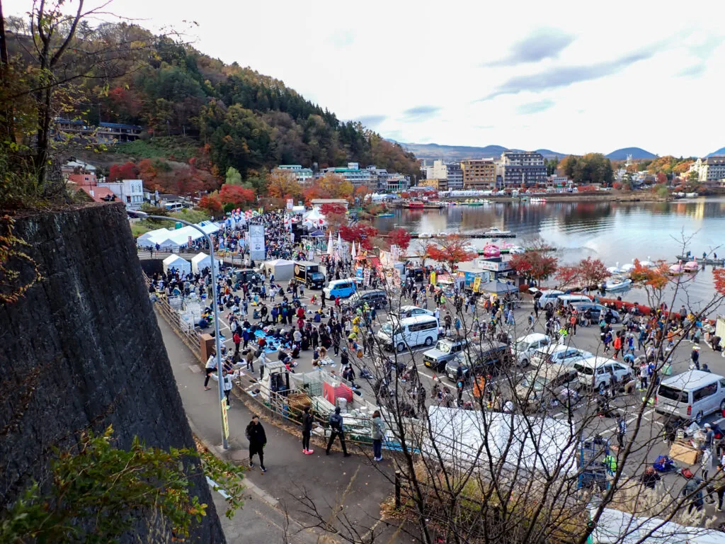 紅葉の山に囲まれた河口湖畔で、テントや参加者でにぎわう大会会場