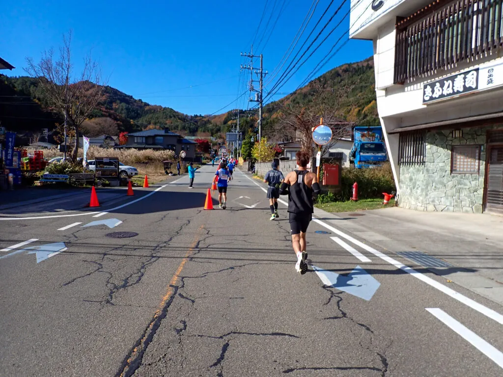 山あいの町の道を、西湖へ向けて上っていくランナーたち