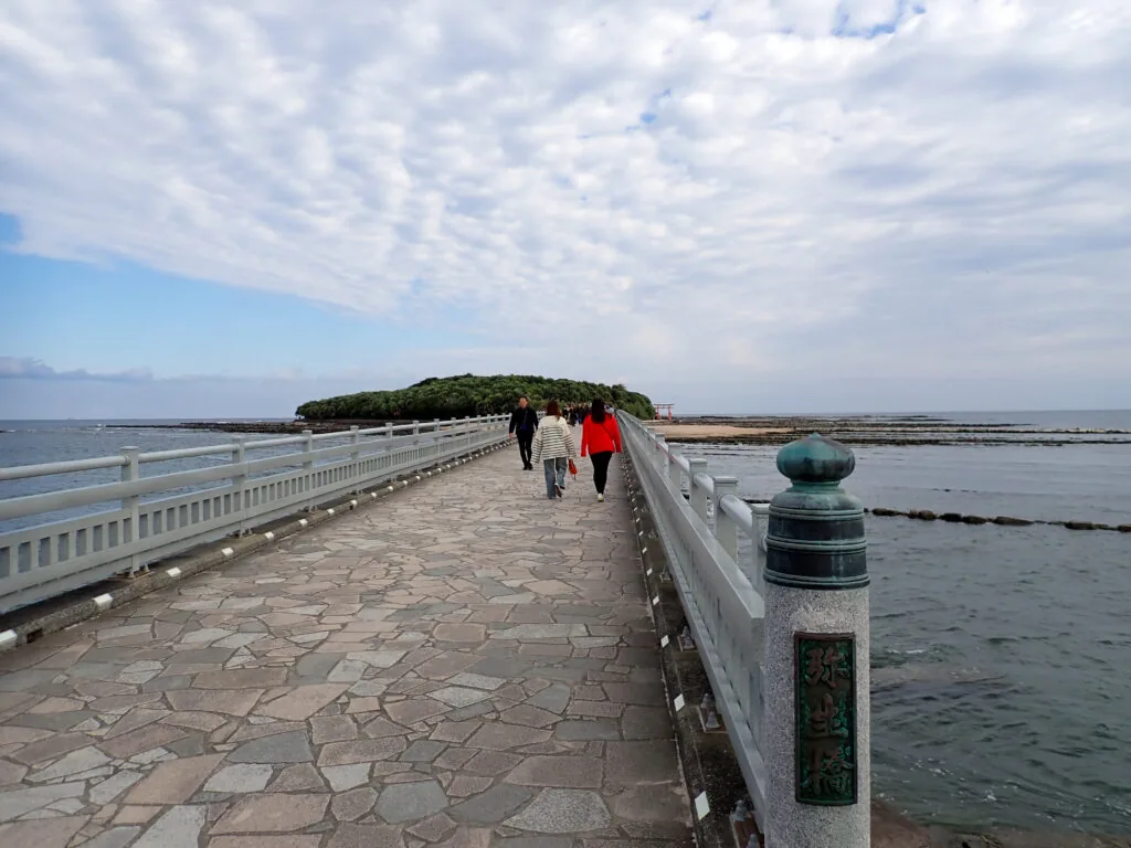 海の上を青島へ続く石畳の橋と、奥に見える緑の島