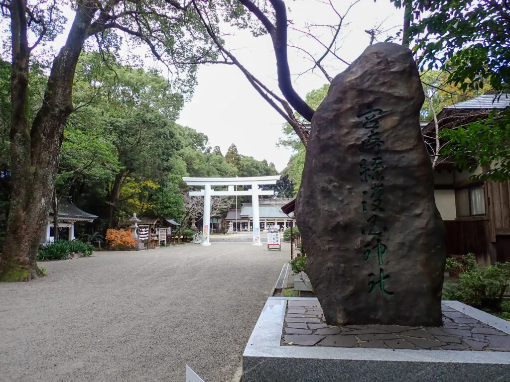 岩に社名を刻んだ宮崎県護国神社の碑と、奥に見える白い鳥居