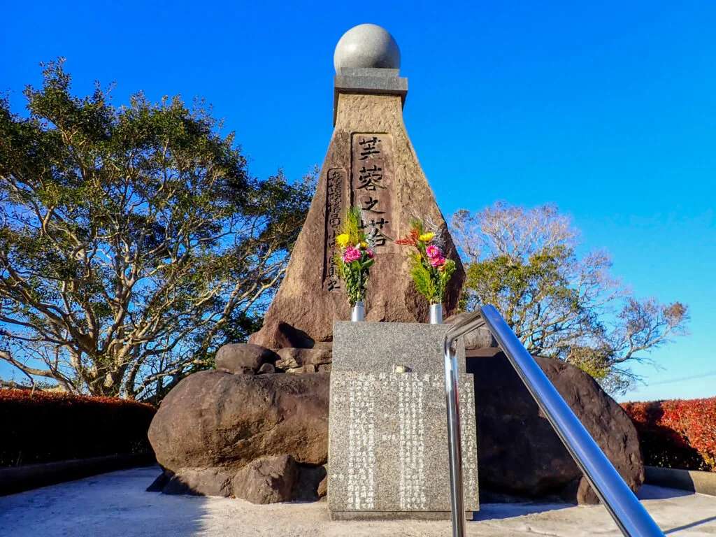 「芙蓉之塔」と刻まれた、先端に球を載せた塔と供えられた花