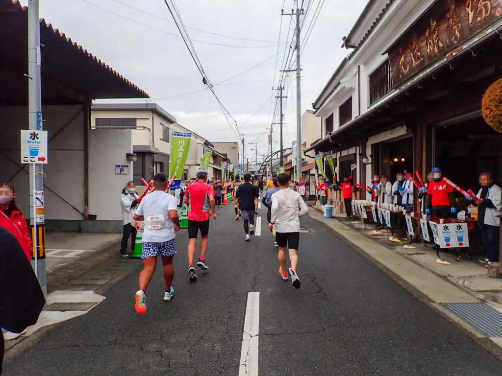 古い商家が並ぶ川尻蔵前通りを走るランナーと沿道の応援
