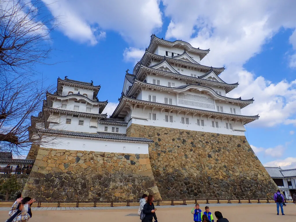 青空にそびえる姫路城の大天守と石垣