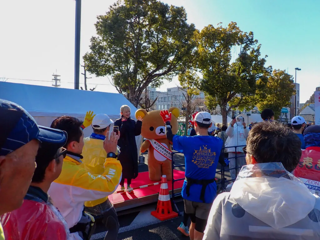 スタート地点のステージで手を振るリラックマとゲスト