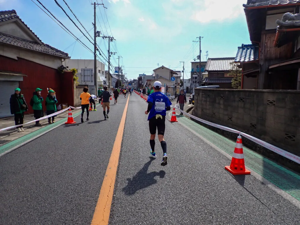 古い家並みが続く道を姫路城へ向かうランナー