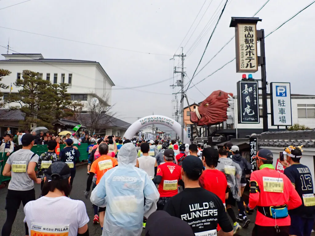 白いスタートゲートの手前でスタートを待つランナーたち