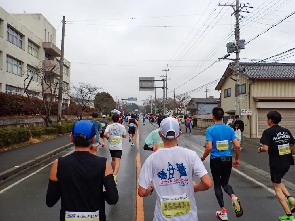 校舎が見える沿道を進むランナーたち