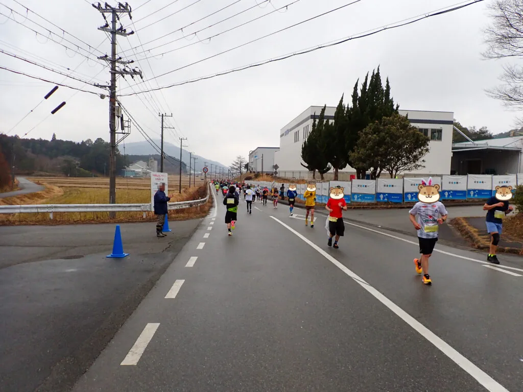 泉工業団地の工場の横を通る道を進むランナーたち