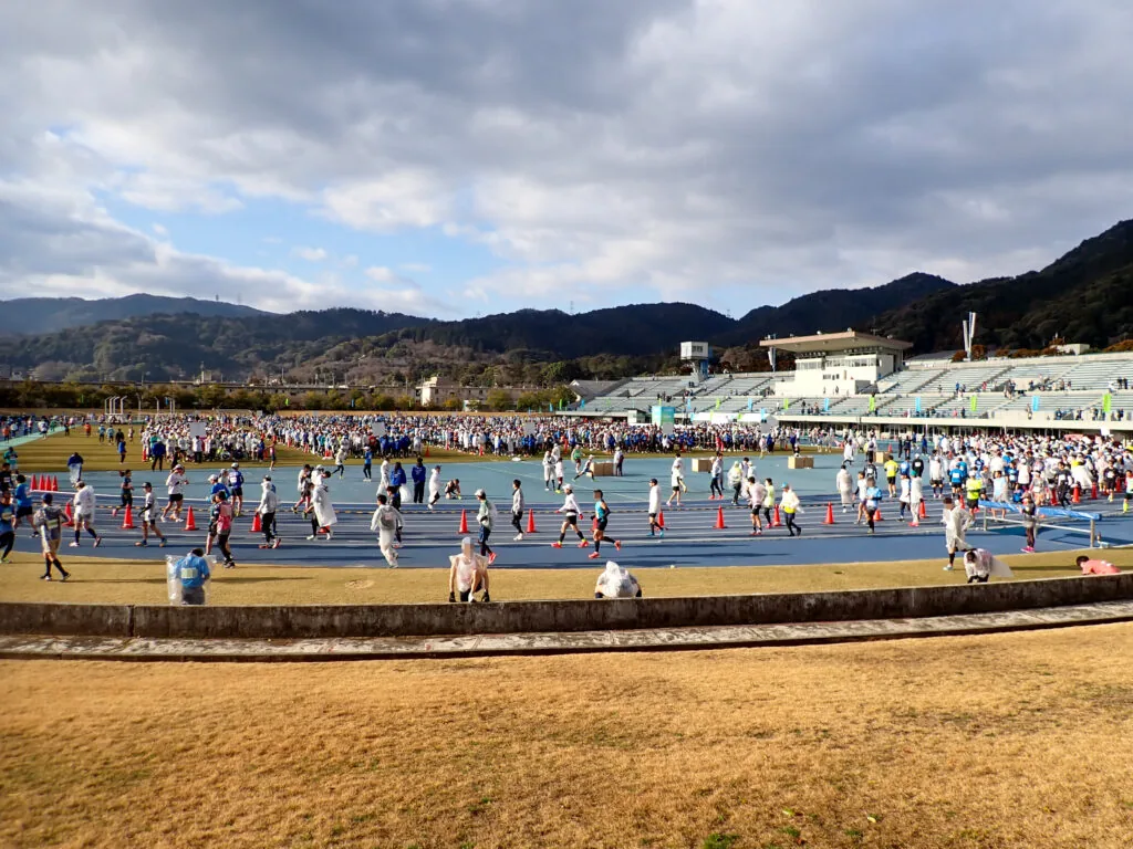 山を背にした皇子山総合運動公園の競技場に集まる参加者たち