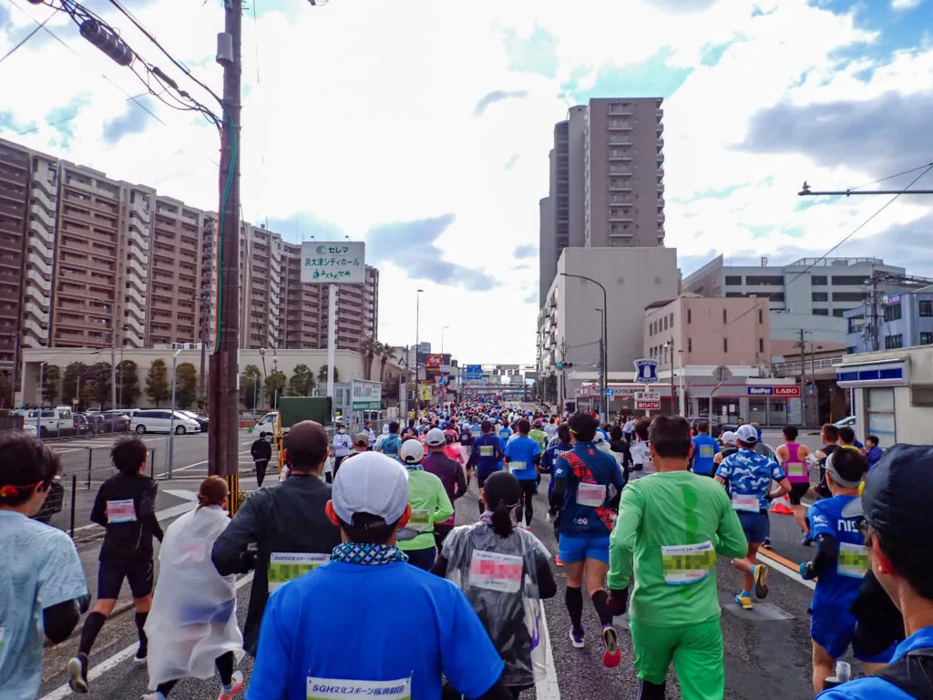 高層マンションが立ち並ぶ市街地を進むランナーたち