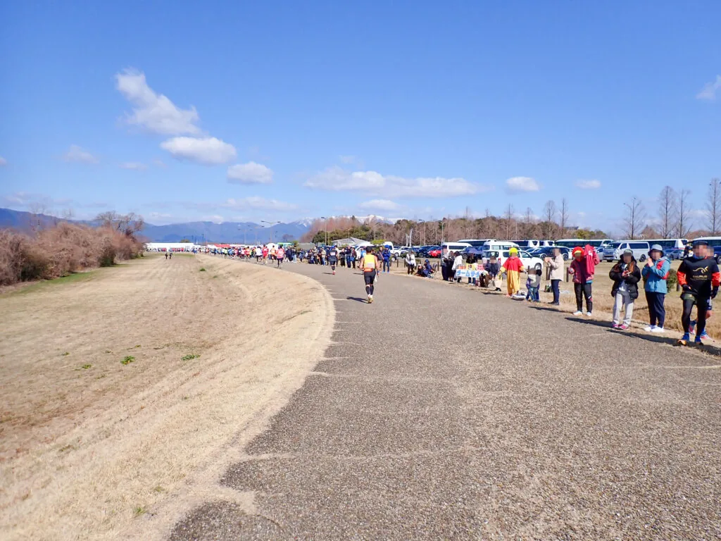 烏丸半島の広い舗装路と沿道に並ぶ応援の人たち