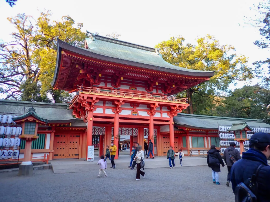 朱塗りの楼門と、境内を歩く参拝の人たち
