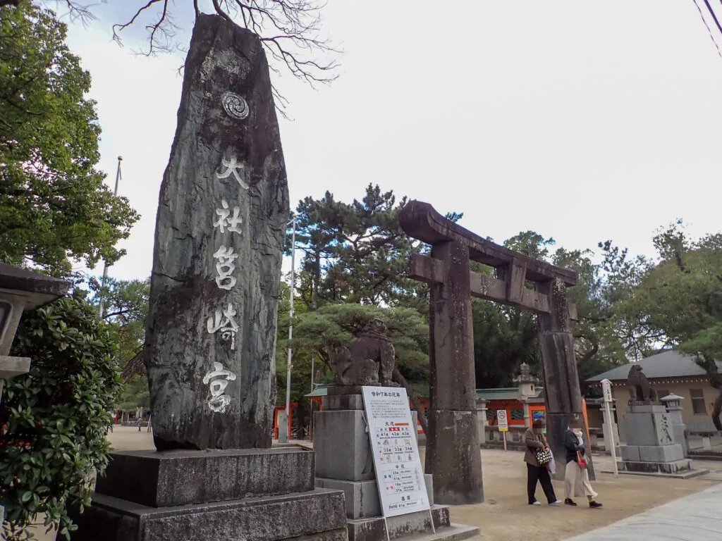 「筥崎宮」と刻まれた大きな石柱と奥に見える鳥居