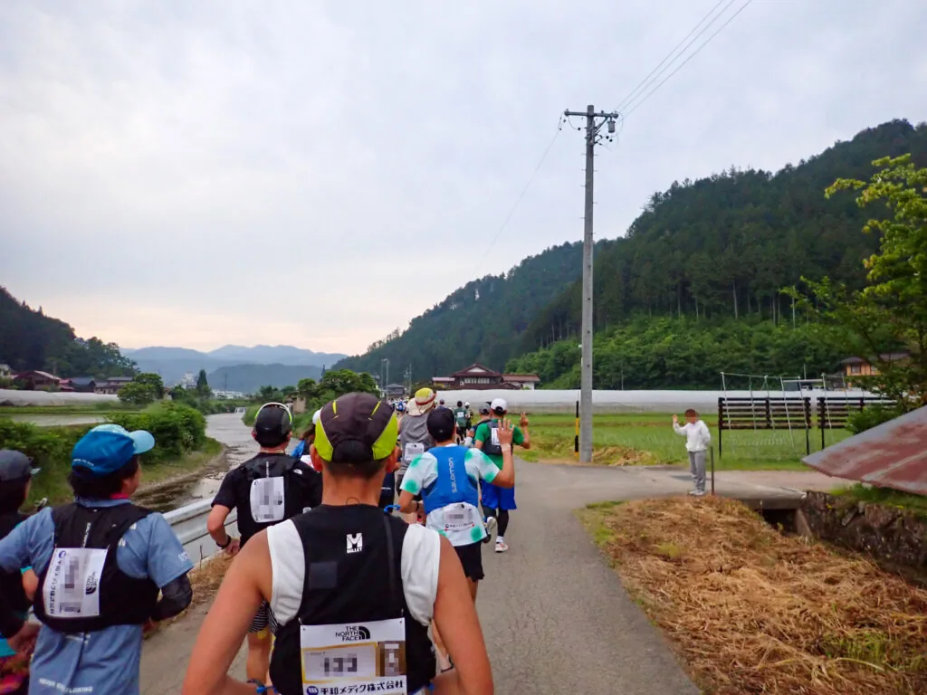 山に囲まれた田園の道を進むランナーたち