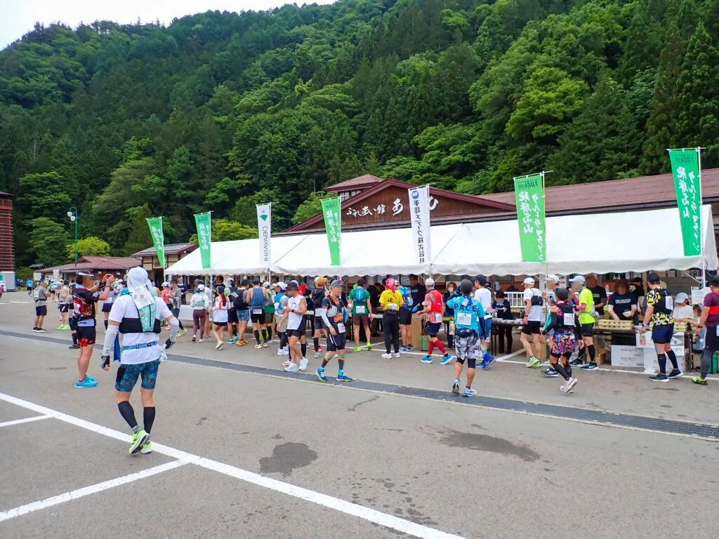 道の駅の駐車場に設けられたエイドに集まるランナーたち