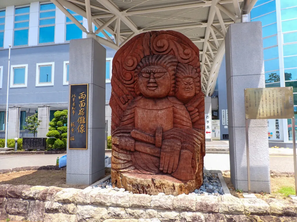屋根の下に据えられた木彫りの両面宿儺像