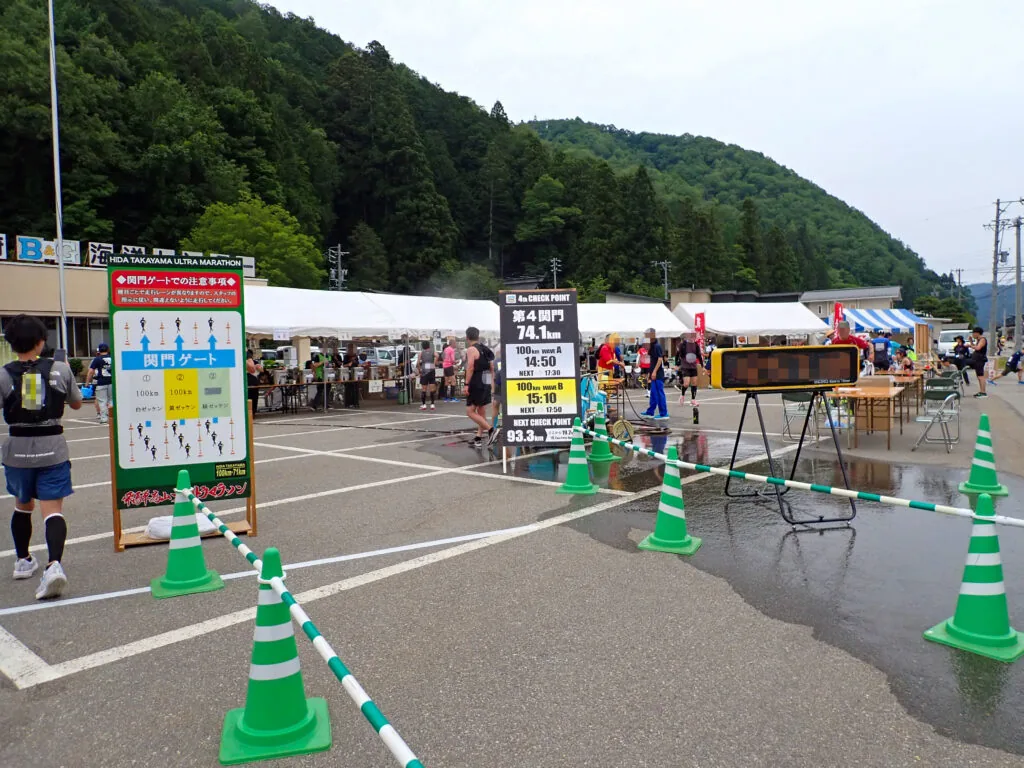 エイドのテントと関門の案内看板が並ぶ第4関門の駐車場
