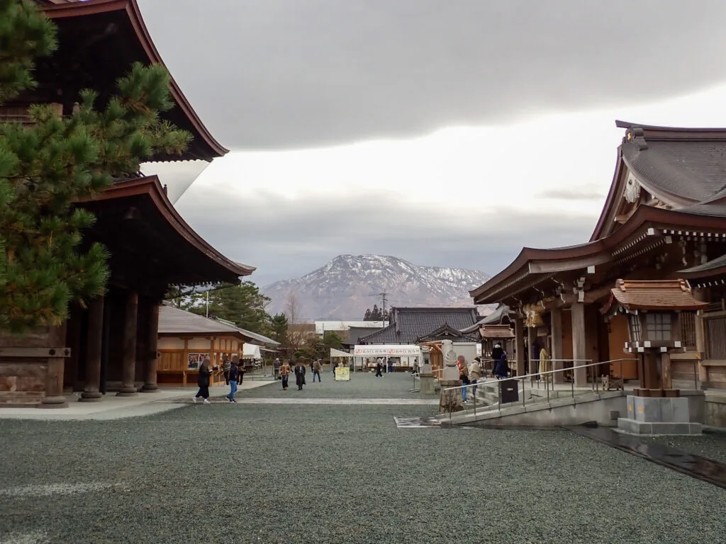 遠くに雪をかぶった山が見える阿蘇神社の境内