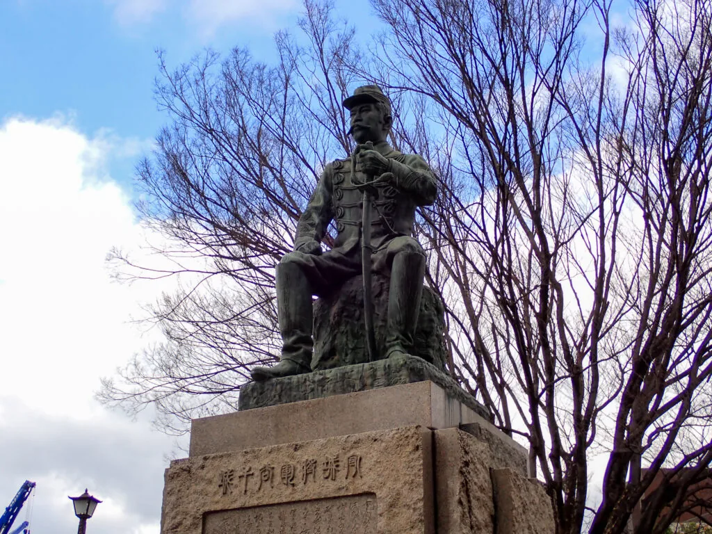 冬木立を背に立つ、軍服姿の谷干城の銅像