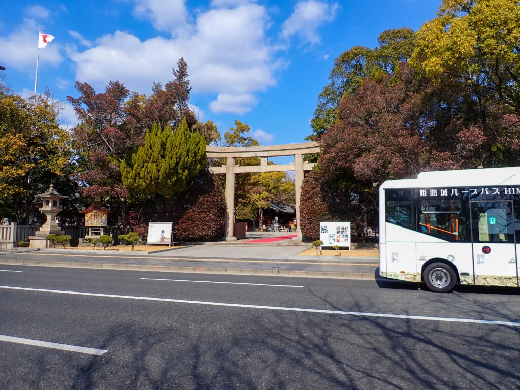 道路越しに見える兵庫縣姫路護国神社の鳥居と、前を通るバス