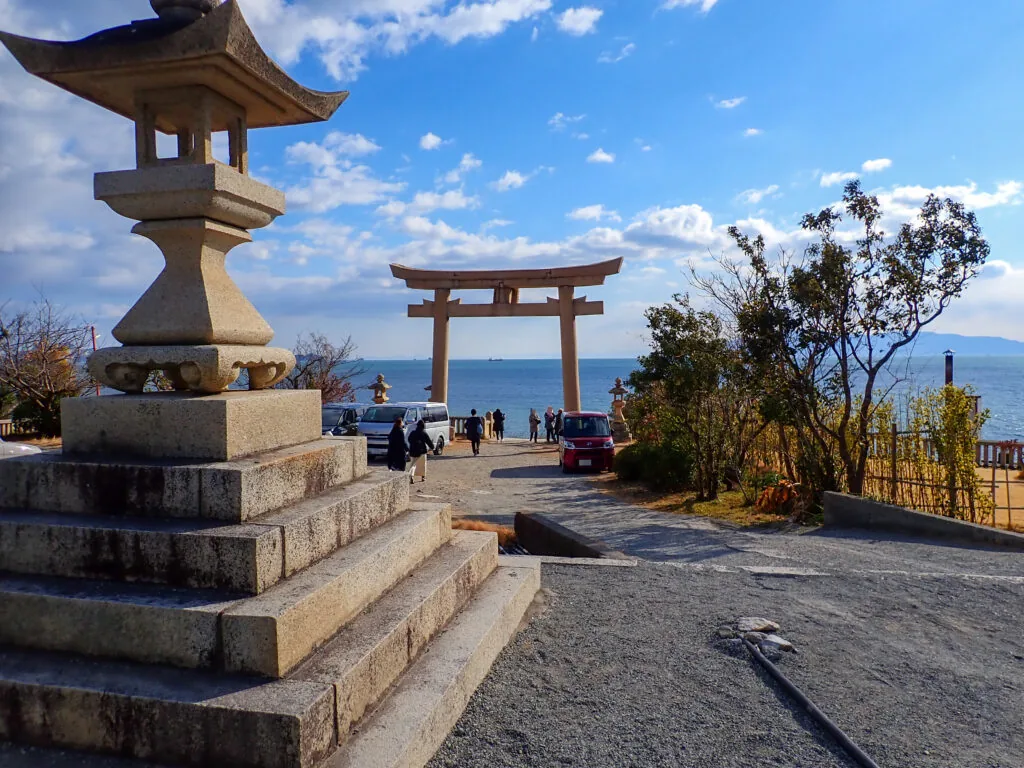 石灯籠の先、鳥居の向こうに海が広がる伊和都比売神社の境内