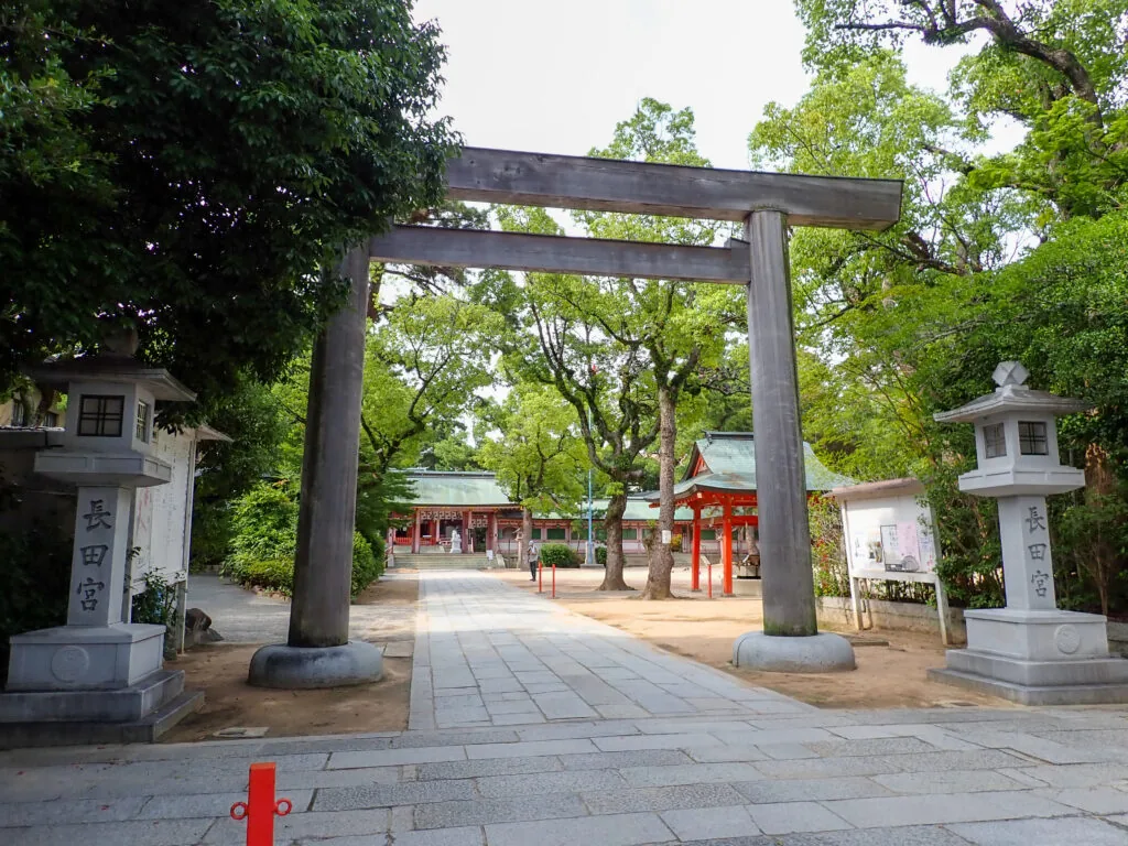 木の鳥居と石灯籠が並ぶ長田神社の参道