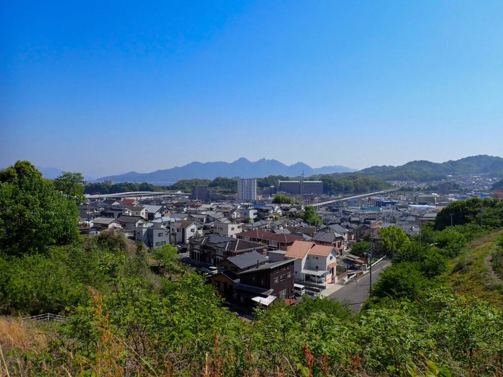 高台から見下ろす町並みと遠くに連なる山々