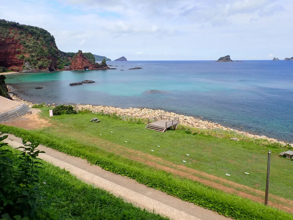 赤茶色の崖と澄んだ海が広がる明屋海岸