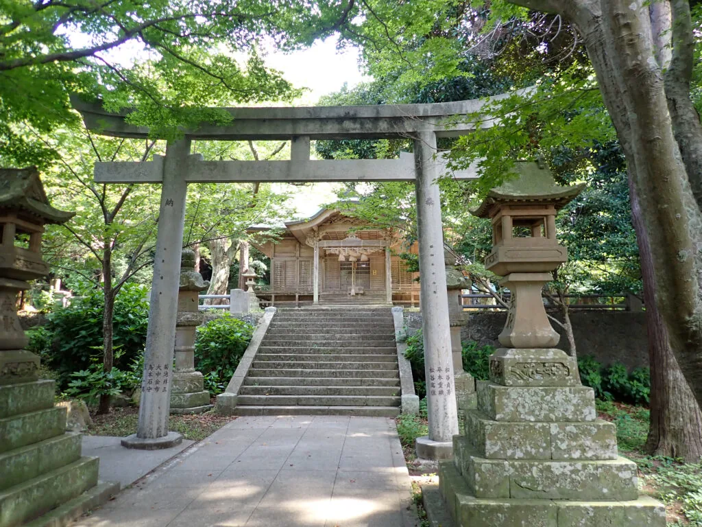 石の鳥居と石灯籠の奥に社殿が見える由良比女神社