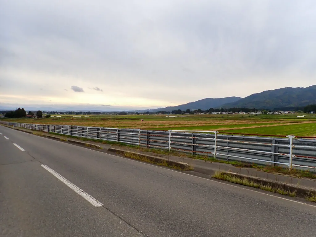 ガードレール越しに見渡す田園と山並み