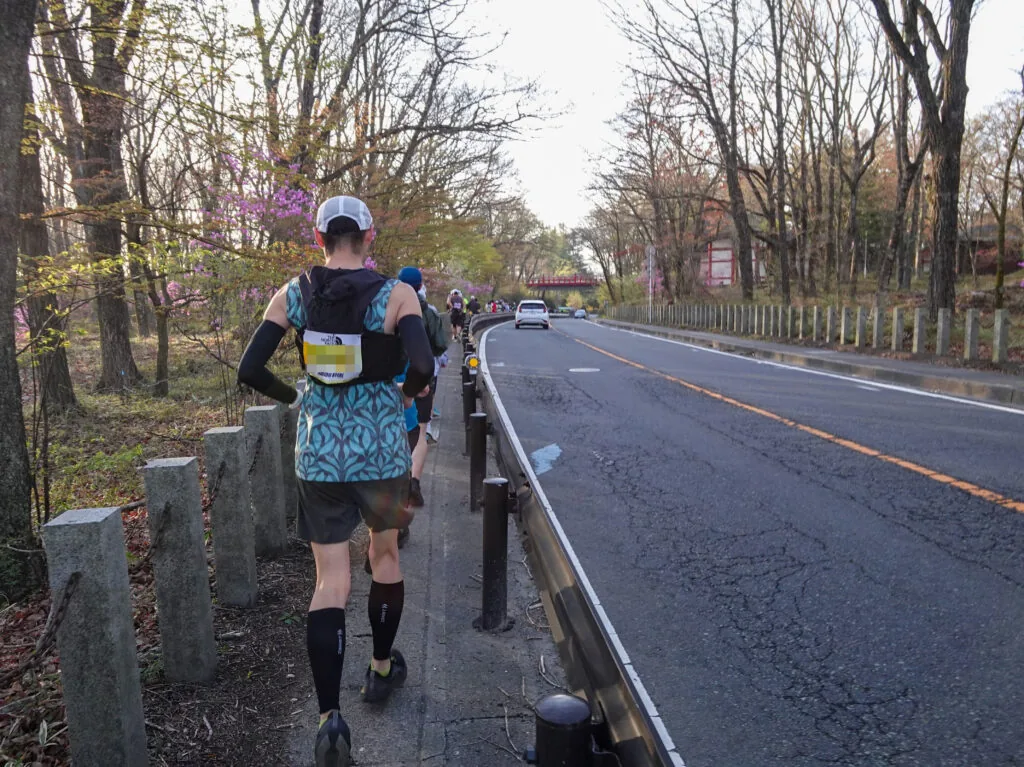 明るくなってきた木立の間の道を走るランナーたち