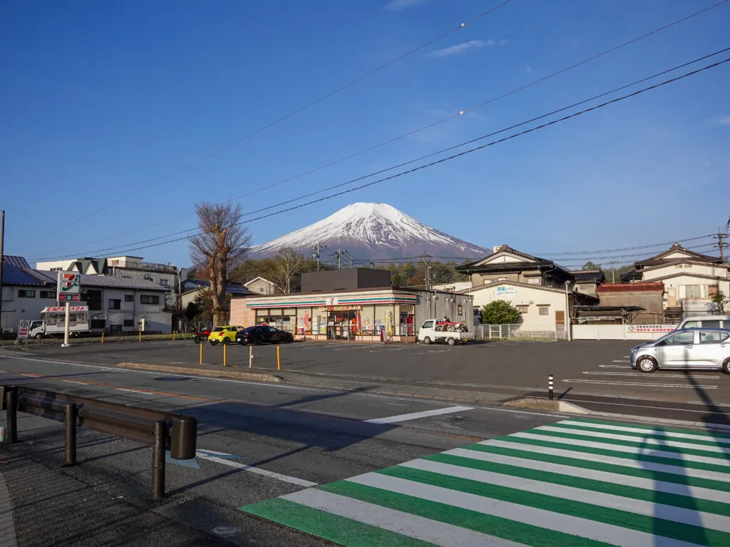 民家の向こうにそびえる冠雪した富士山