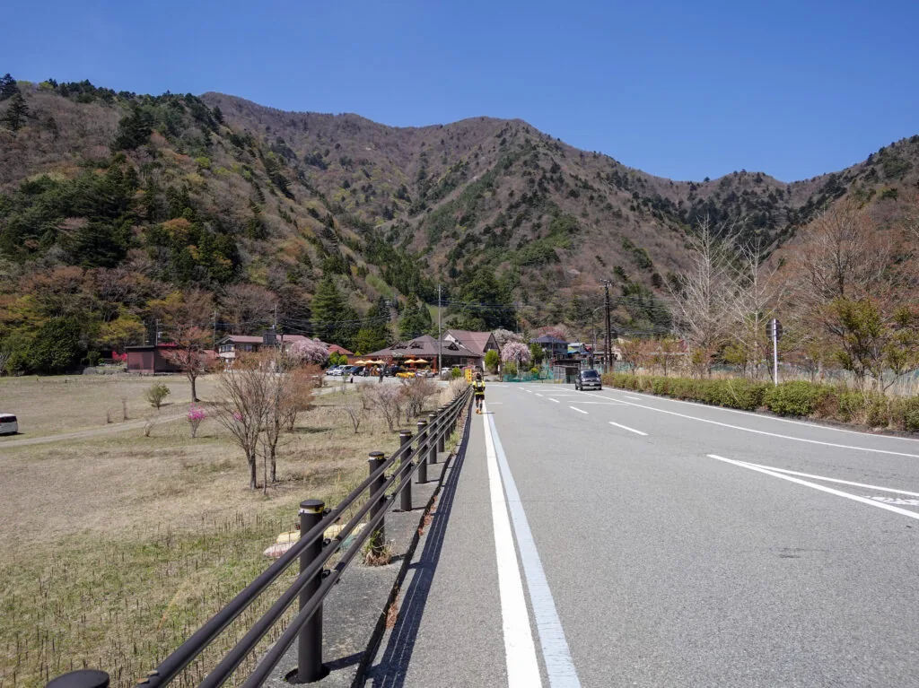道路の正面にそびえる山並みと、麓の集落