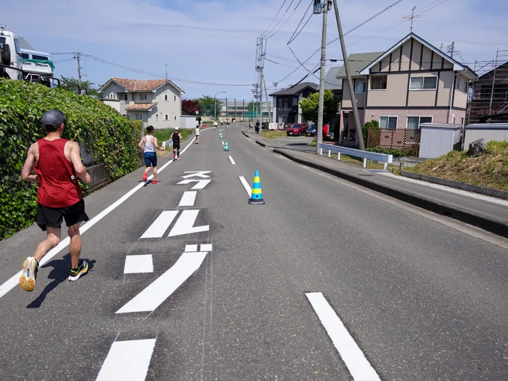住宅が並ぶ道を走るランナーたち