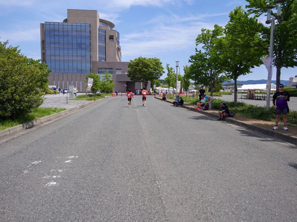 ゴール会場が近づく並木道と、奥に見える建物