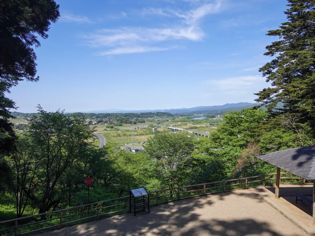 高台の展望所から見渡す緑の平野と遠くの山並み